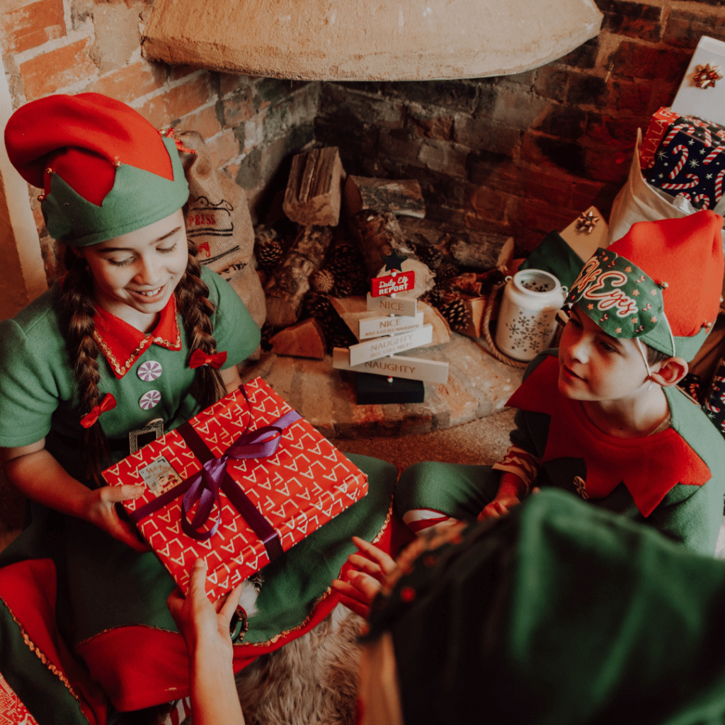 Children Wearing Elf Costumes Receiving Presents